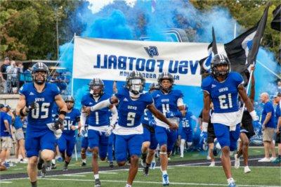 GVSU football team runs on to Lubbers Stadium field at start of game.